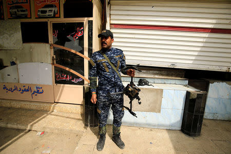 A member of federal police carries a destroyed drone belonging to Islamic State militants, in Mosul. REUTERS/Thaier Al-Sudani