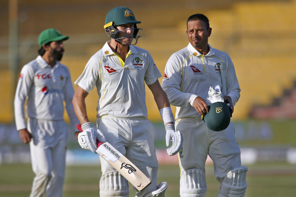 Australia's Usman Khawaja, right, and Marnus Labuschagne, center, walk back to pavilion at the end of the third day play of the second test match between Pakistan and Australia at the National Stadium in Karachi, Pakistan, Monday, March 14, 2022. (AP Photo/Anjum Naveed)