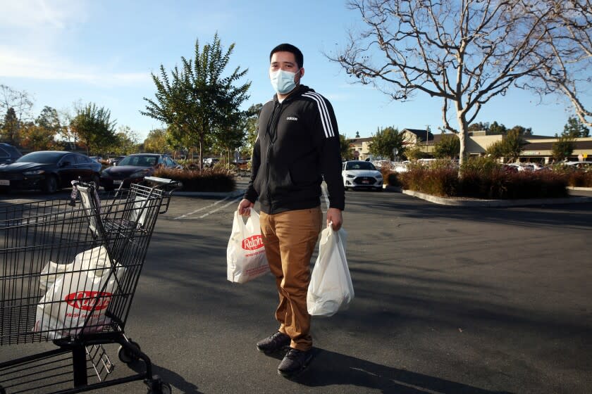 LONG BEACH, CA - FEBRUARY 02: David Morales, an InstaCart shopper, exits a Ralphs store with a customers order and he frequents the Ralphs that Kroger, its parent company will shut down in response to the city imposing a "hero pay" increase of 4 dollars per house on Tuesday, Feb. 2, 2021 in Long Beach, CA. The Ralphs is located at 3380 N. Los Coyotes Diagonal. (Dania Maxwell / Los Angeles Times)