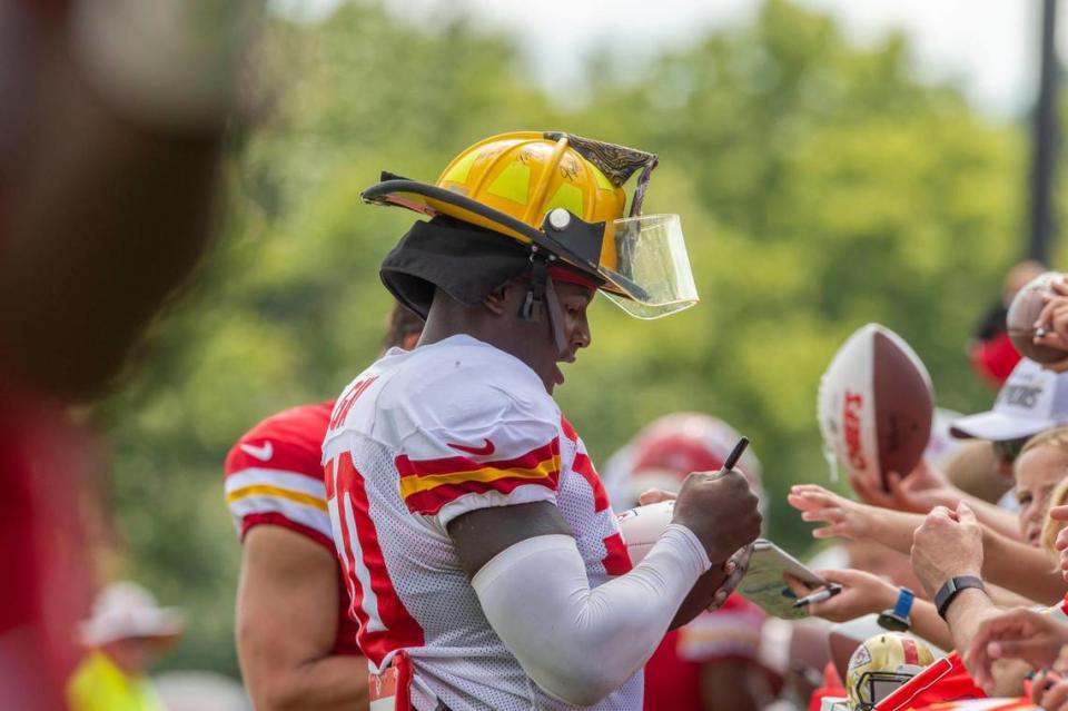 Kansas City Chiefs linebacker Willie Gay (50) signs autographs while wearing a fan’s firefighter helmet after practice at Chiefs training camp on Wednesday, Aug. 17, 2022, in St. Joseph.