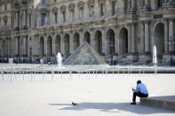 A lone man sit in the shadow in the courtyard of the Louvre museum, which is outside the security perimeter set up for the Olympic Games, Friday, July 19, 2024, in Paris, France. (AP Photo/David Goldman)