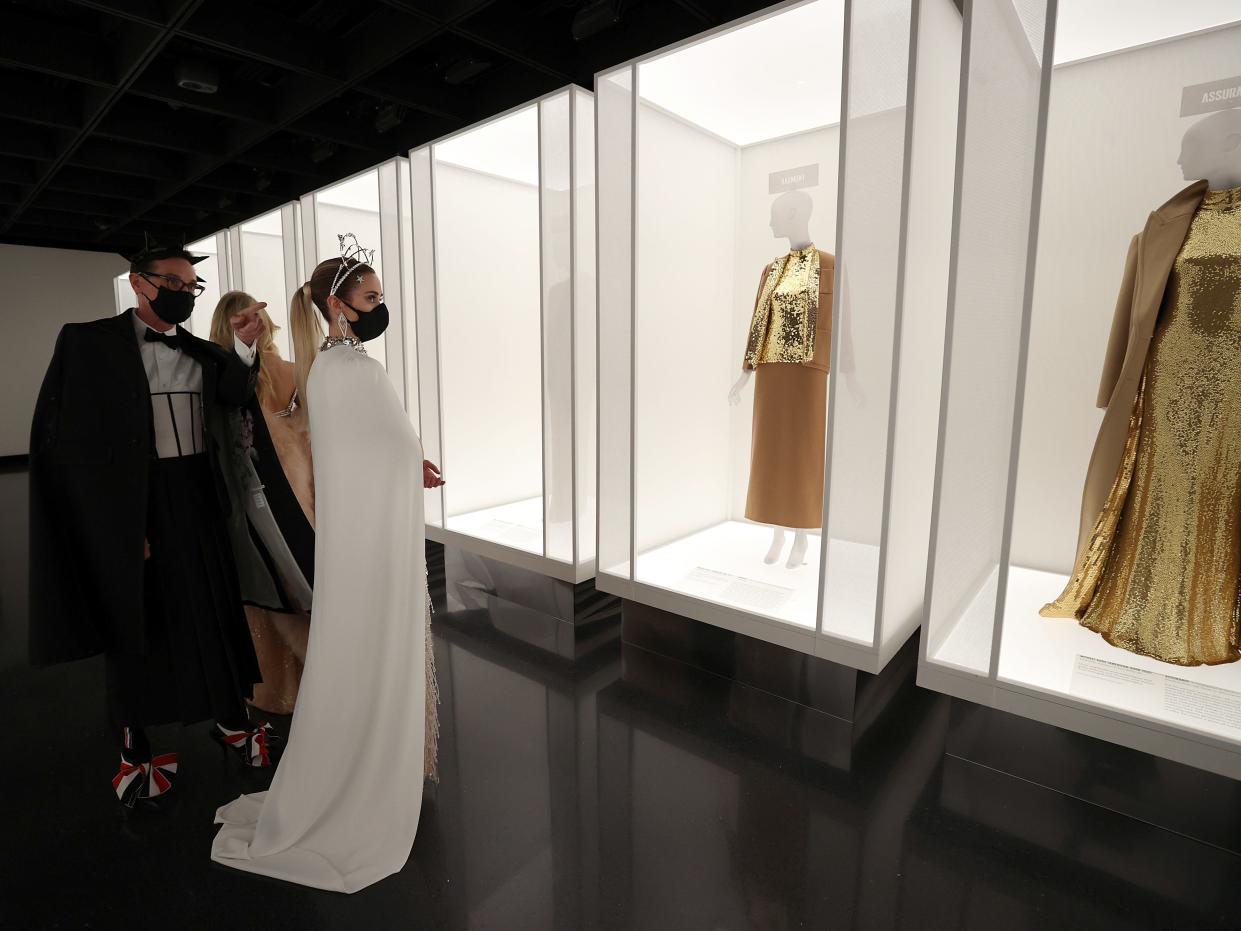 Guests of the 2021 Met Gala look at the exhibit.