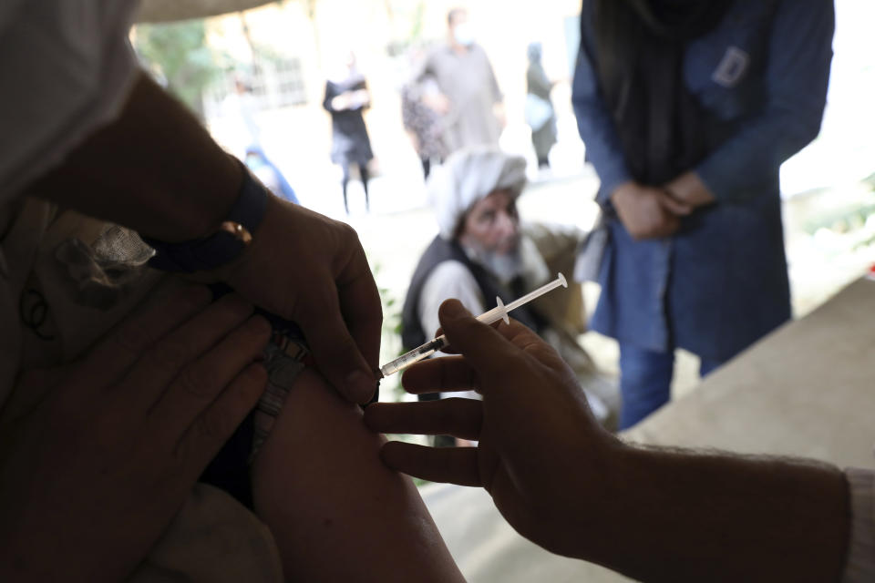 FILE - In this Sunday, July 11, 2021 file photo, a woman receives the Johnson & Johnson COVID-19 vaccine at a vaccination center with COVID-19 vaccines donated by the United States and delivered through the U.N.-backed COVAX program, in Kabul, Afghanistan. In late June, the international system for sharing coronavirus vaccines sent about 530,000 doses to Britain – more than double the amount sent that month to the entire continent of Africa. It was the latest example of how a system that was supposed to guarantee low and middle-income countries vaccines is failing, leaving them at the mercy of haphazard donations from rich countries. (AP Photo/Rahmat Gul, file)