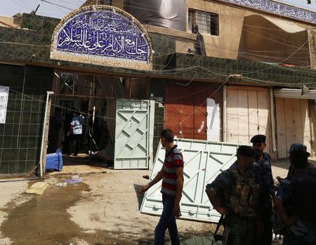 Iraqi security forces stand guard outside a Shi'ite mosque after a suicide bomb attack in the New Baghdad district, eastern Baghdad, August 25, 2014. REUTERS/Thaier al-Sudani