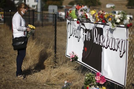 Leanne DiLorenzo, 48, leaves flowers at a memorial outside Umpqua Community College in Roseburg, Oregon, United States, October 3, 2015.REUTERS/Lucy Nicholson