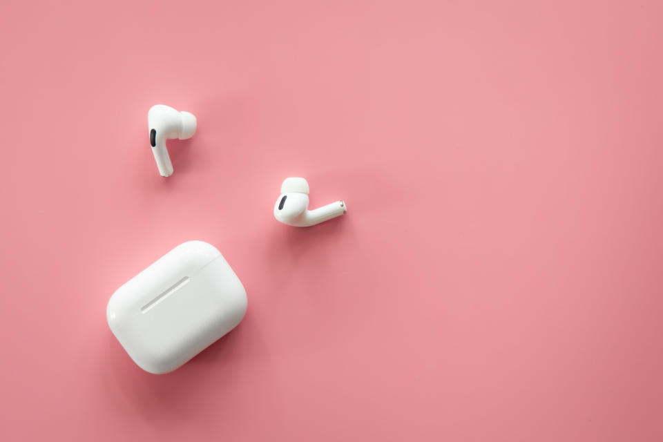 Wireless in-ear headphones with a case on a pink background, flat lay, conceptual minimalism. Amazon prime day 2024