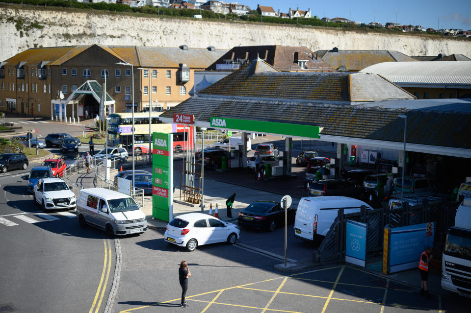 BRIGHTON, ENGLAND - SEPTEMBER 24: A man looks on as drivers queue to enter a supermarket petrol station as concern spreads over fuel supplies on September 24, 2021 in Brighton, England. BP and Esso have announced that its ability to transport fuel from refineries to its branded petrol station forecourts is being impacted by the ongoing shortage of HGV drivers and as a result, it will be rationing deliveries to ensure continuity of supply. (Photo by Leon Neal/Getty Images)