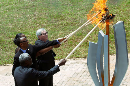 African Union Commission Chairperson Moussa Faki Mahamat, Rwandan President Paul Kagame, Jeannette Kagame and European Commission President Jean-Claude Juncker, light the flame of hope during a commemoration ceremony of the 25th anniversary of the genocide at the Genocide Memorial in Gisozi in Kigali, Rwanda. April 7, 2019.REUTERS/Baz Ratner