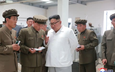 Kim Jong-un regularly doles out advice to North Korean workers, in this case at a machine factory in a coal mining complex - Credit: KCNA/Reuters
