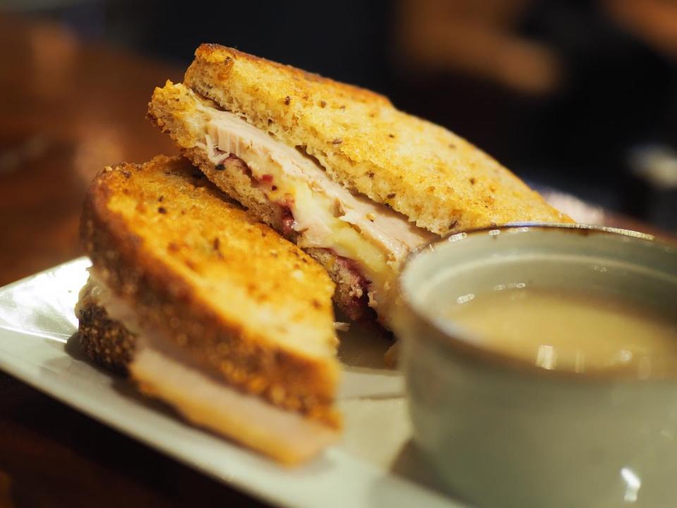 Home Grown Café in Newark offers a Grilled Turkey Dinner sandwich made with turkey, mashed potatoes, cranberry compôte, herb aioli and Muenster cheese on multigrain bread with a side of gravy.