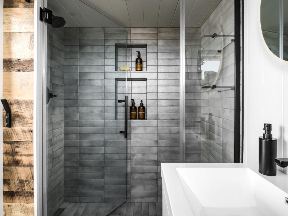 a large glass shower besides a sink