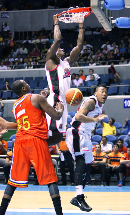 Alaska's Robert Dozier slams it home while Meralco's Eric Dawson looks on. (PBA Images)