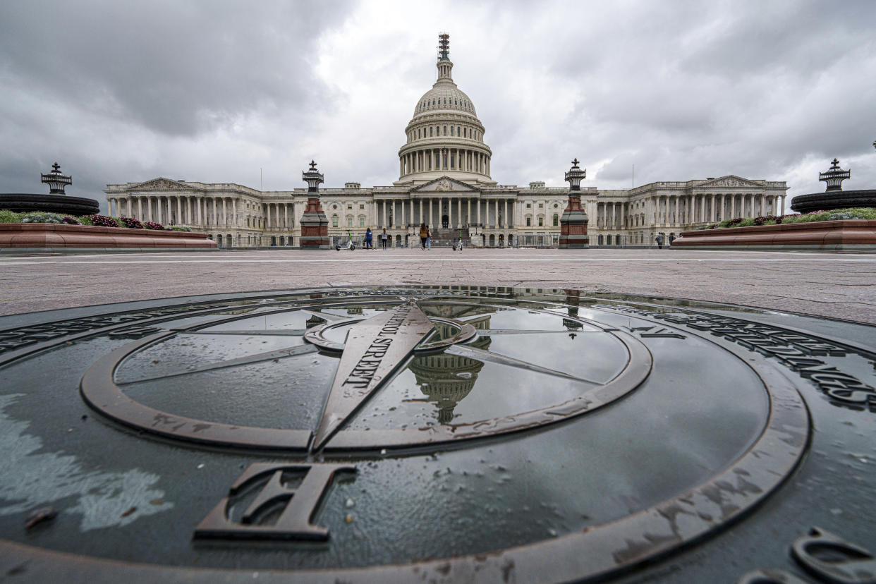 The U.S. Capitol Dome is reflected in a rain puddle on the compass star on the east side of the building as a government shutdown looms.