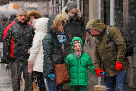 A young boy yawns while walking through the Times Square neighborhood during a snowfall in New York, U.S., February 12, 2019. REUTERS/Lucas Jackson