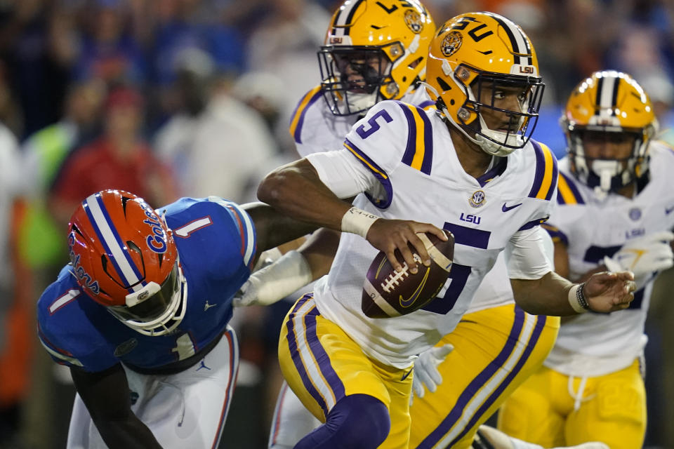 LSU quarterback Jayden Daniels (5) scrambles from the pocket as Florida linebacker Brenton Cox Jr. (1) cannot make a tackle during the first half of an NCAA college football game, Saturday, Oct. 15, 2022, in Gainesville, Fla. (AP Photo/John Raoux)