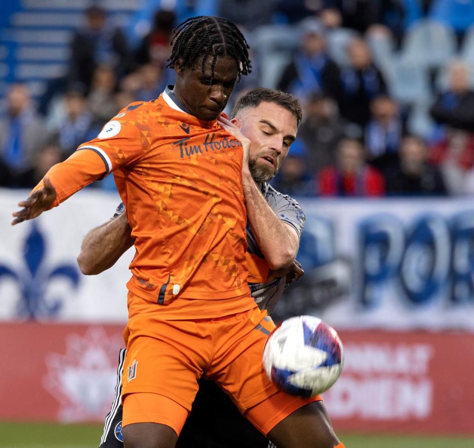 CF Montreal's Rudy Camacho (4) battles with Forge FC's Woobens Pacius (17) during first half Canadian Championship semifinal soccer action in Montreal on Wednesday, May 24, 2023.  (Allen McInnis/Canadian Press - image credit)