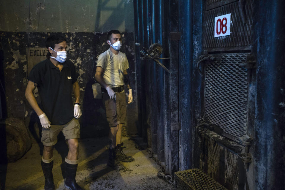 In this Monday Jan. 13, 2020 photo, zoo keepers Santiago Gentili, left, and Marcos Flores prepare to give veterinary attention to Asian elephant Mara at the former city zoo now known as Ecopark in Buenos Aires, Argentina. Mara will leave her enclosure and be moved to a special sanctuary in Brazil, but before her trip to the neighboring country expected to take place in March, the 55-year-old is undergoing a training process to prepare her for confinement during the 2,500 kilometers road trip, that will last two or three days. (AP Photo/Daniel Jayo)