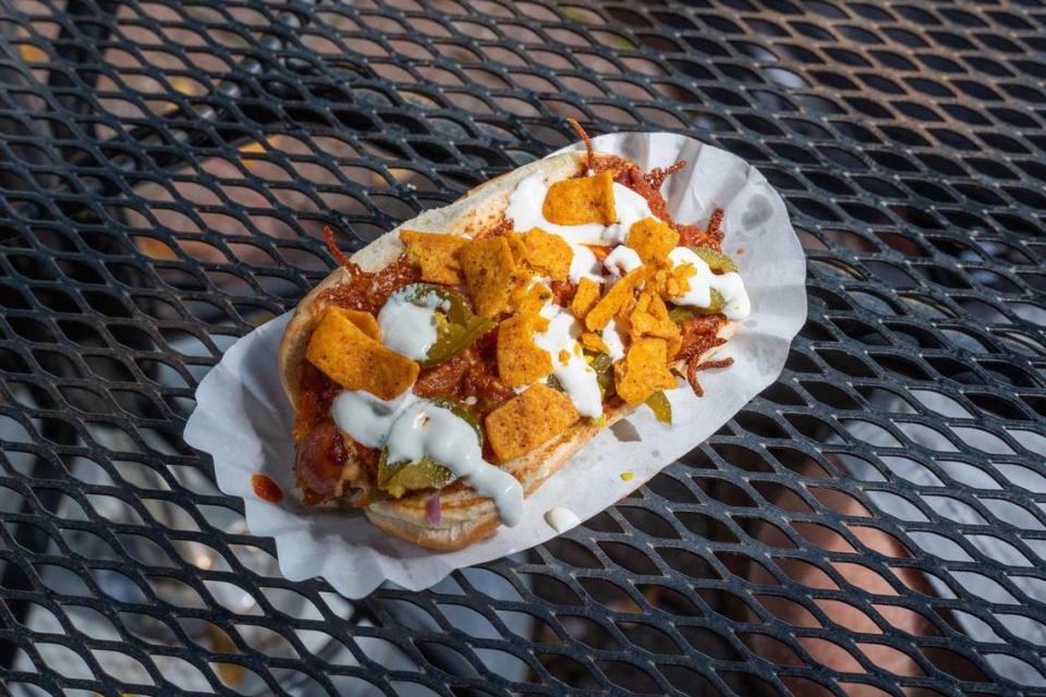 A Frito Pie Dog from The Chili Man’s hot dog cart with grilled chedder cheese, taco juice, chili, onion, jalepenos, sour cream, and crushed chili cheese Fritos.