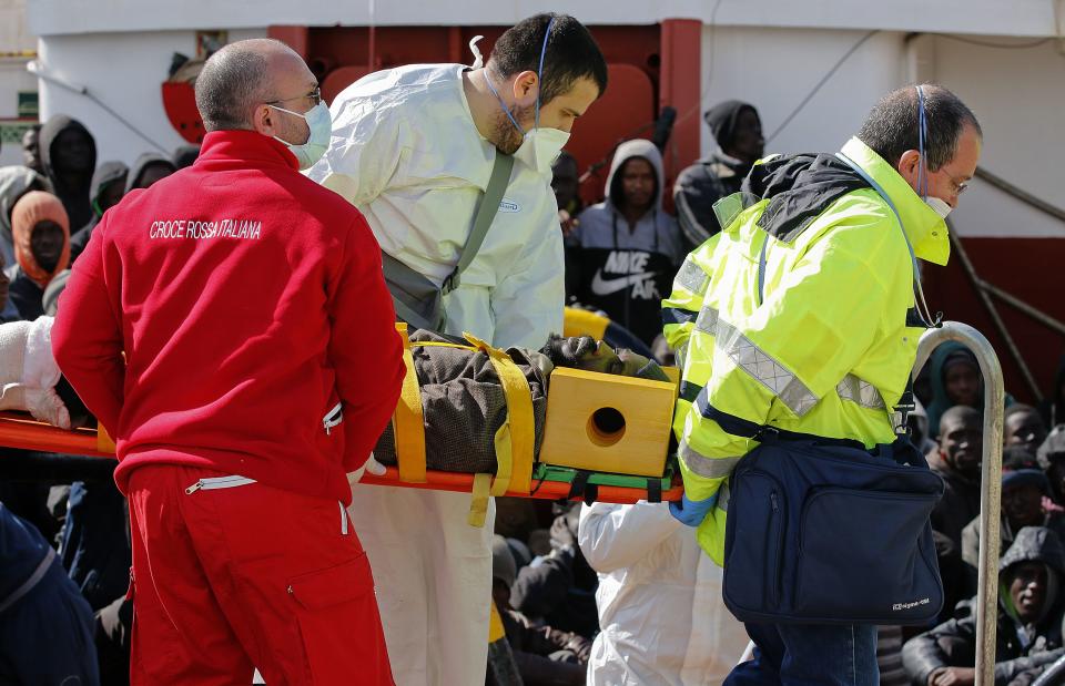 A migrant is helped by Red Cross assistants as he arrives at the Sicilian harbour of Pozzallo