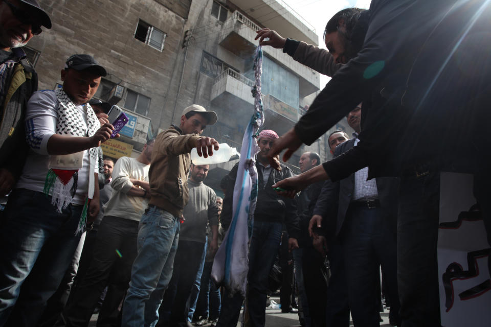 Protesters affiliated with Jordan's Muslim Brotherhood against U.S. Secretary of State John Kerry's peace talks burn a representation of the Israeli flag during a demonstration in downtown Amman, Jordan, Friday, Feb. 14, 2014. Hours before Jordan's King Abdullah II met with U.S. President Barack Obama in California, his Islamist opposition at home has staged its largest protest in several months to reject a peaceful Mideast settlement. (AP Photo/Mohammad Hannon)