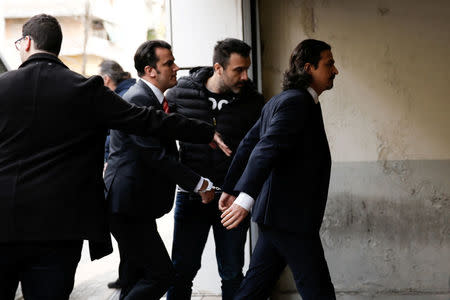 Two of the eight Turkish soldiers, who fled to Greece in a helicopter and requested political asylum after a failed military coup against the government, are escorted by police officers as they arrive at the appeals court in Athens, Greece, March 16, 2018. REUTERS/Costas Baltas