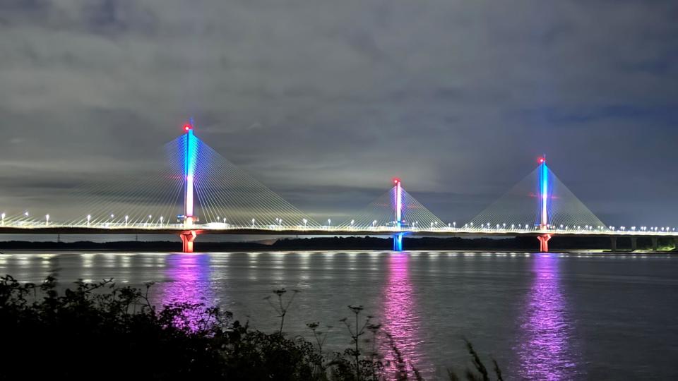 The Mersey Gateway Bridge lit up orange and blue 