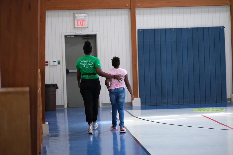 ViaFaith McCullough, Project Transformation program director, assists a young camper who fell during a Movement Minutes game in the gymnasium at New Hope United Methodist Church, 11600 N Council.