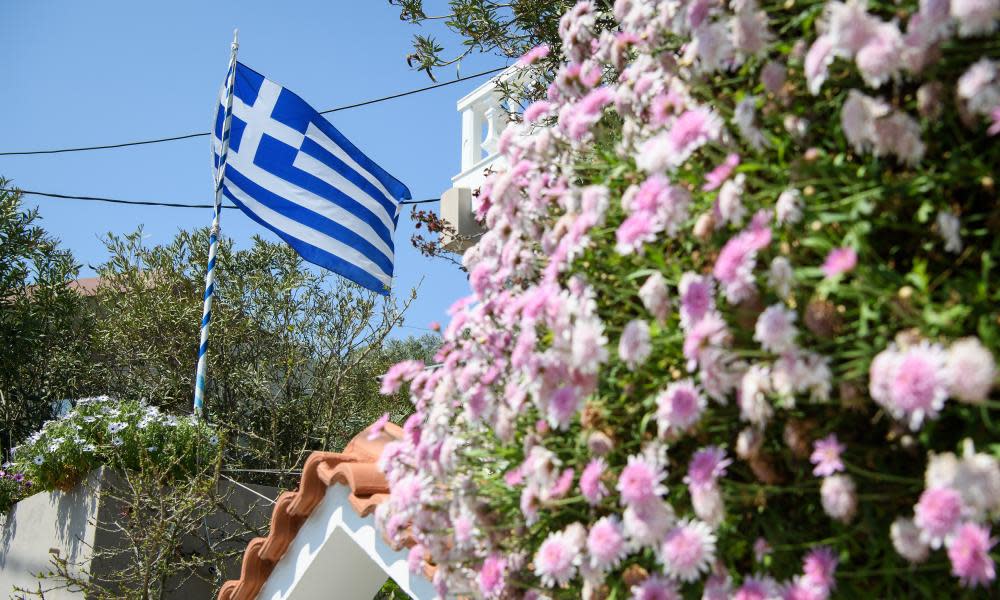 The Greek flag flies in a garden