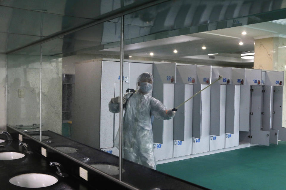 An employee wearing a protective gear disinfects to help curb the spread of the coronavirus at the Ryugyong Health Complex's public bath in Pyongyang, North Korea, Friday, July 31, 2020. (AP Photo/Cha Song Ho)