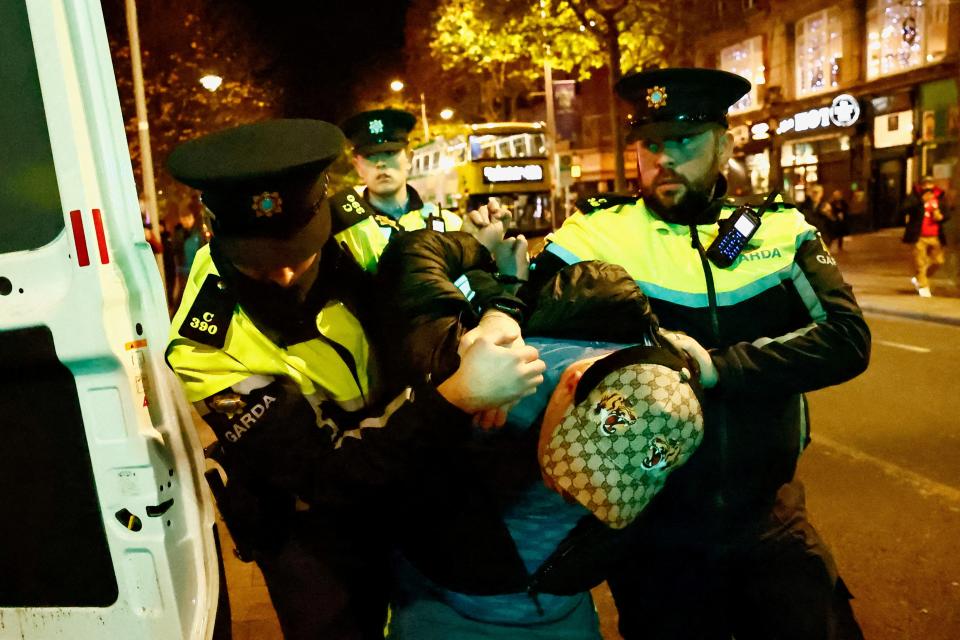 Members of the Garda Public Order Unit detain a man, following the riot in the aftermath of the school stabbing in Dublin (REUTERS)