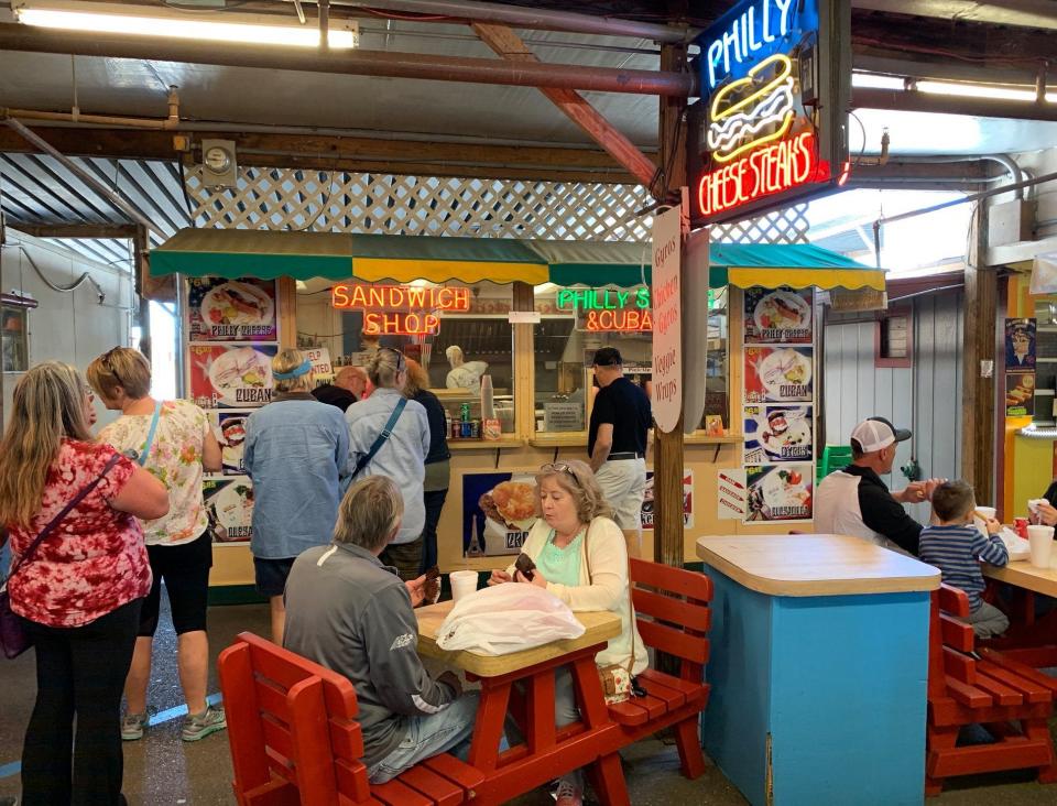 Shoppers at Fleamasters in Fort Myers take a break to enjoy some local food.