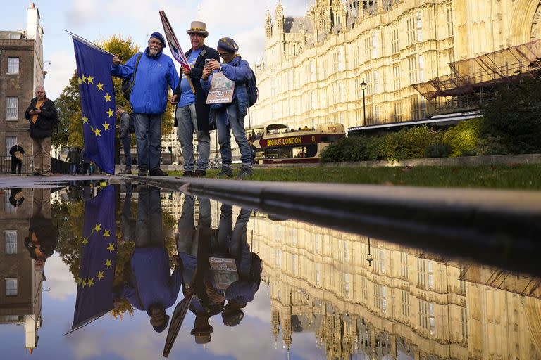 Un grupo de personas se manifiesta frente al Parlamento británica tras la renuncia de la primera ministra Liz Truss, en Londres, el jueves 20 de octubre de 2022. (AP Foto/Alberto Pezzali)