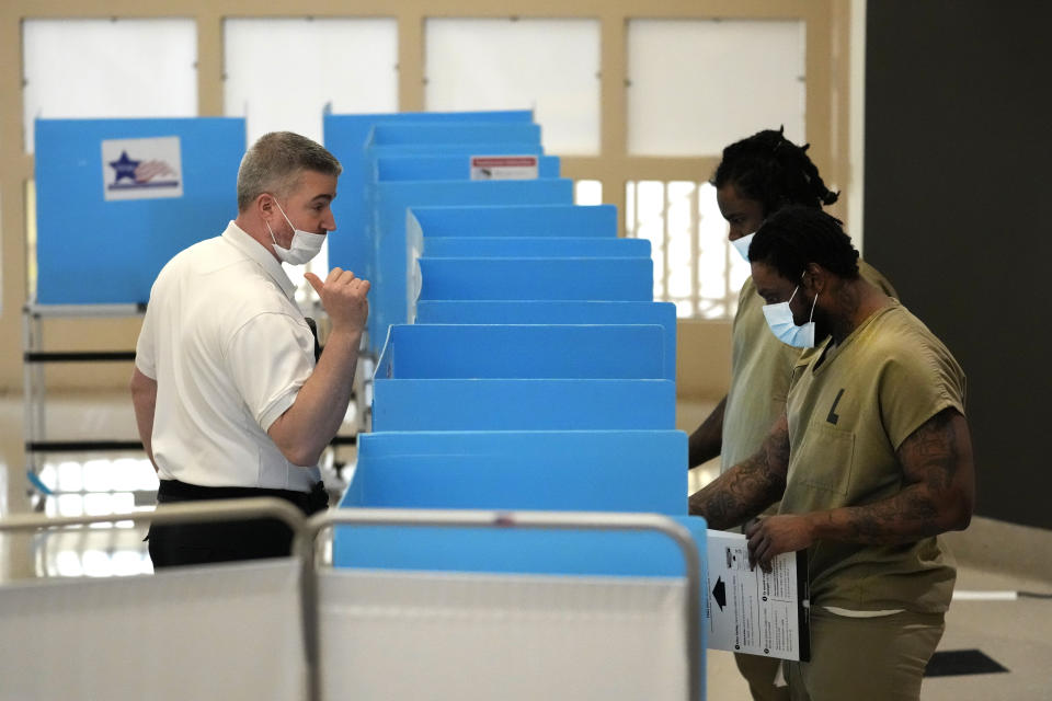 Cook County Corrections Sgt. Robert Mulac talks with inmates at the jail as they vote in the local election at the Division 11 chapel on Saturday, Feb. 18, 2023, in Chicago. (AP Photo/Charles Rex Arbogast)