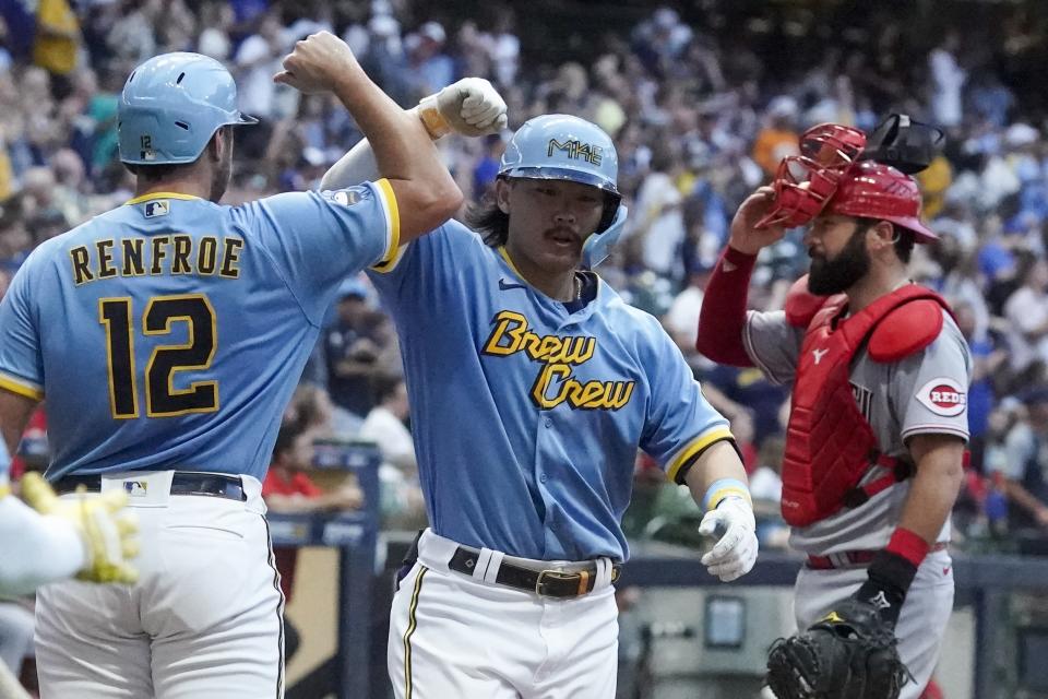 Milwaukee Brewers' Keston Hiura is congratulated by Hunter Renfroe after hitting a two-run home run during the fourth inning of a baseball game against the Cincinnati Reds Saturday, Aug. 6, 2022, in Milwaukee. (AP Photo/Morry Gash)