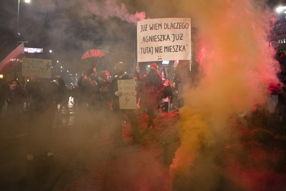 People take part in a protest against a top court ruling restricting abortions in Warsaw, Poland, Wednesday, Nov. 18, 2020. The banner reads "Now I know why Agnes doesn't live here anymore" a reference to a Polish popular song. (AP Photo/Agata Grzybowska)