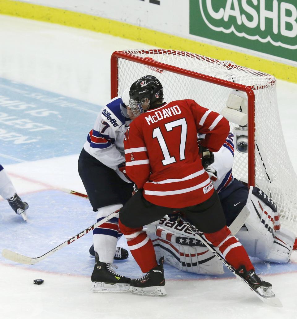 Canada's McDavid gets the puck just before scoring past United States' Kerdiles and goalie illies during the third period of their IIHF World Junior Championship ice hockey game in Malmo