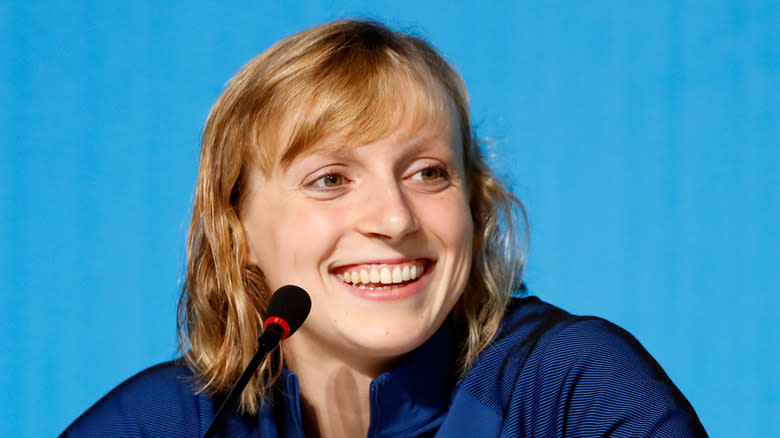 Katie Ledecky smiling at a microphone