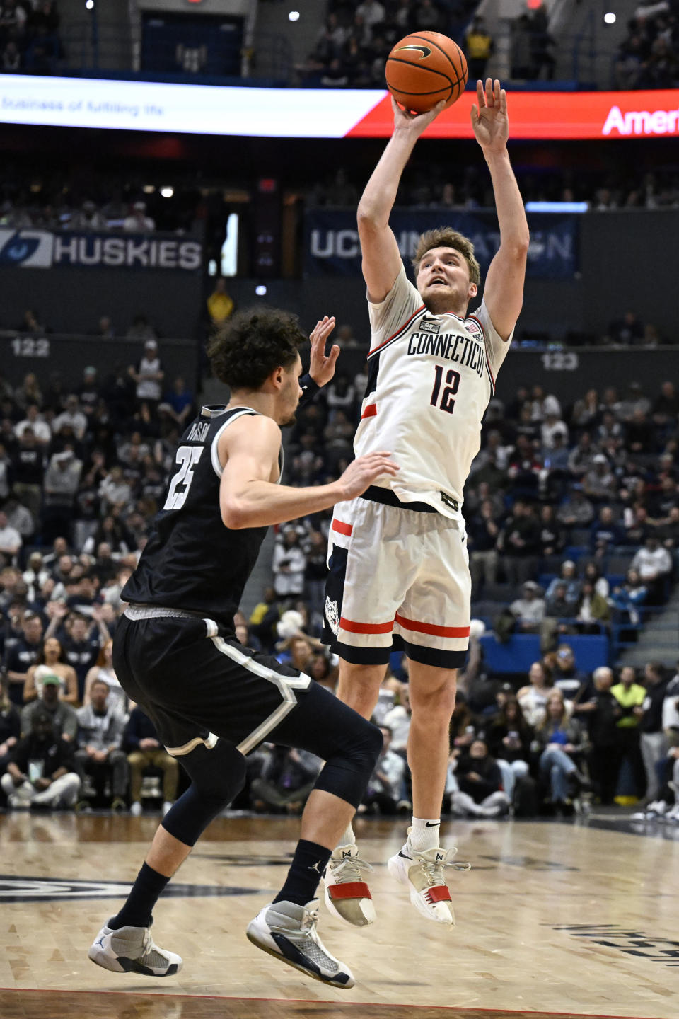 UConn guard Cam Spencer (12) shoots over Georgetown forward Ismael Massoud (25) in the second half of an NCAA college basketball game, Sunday, Jan. 14, 2024, in Hartford, Conn. (AP Photo/Jessica Hill)
