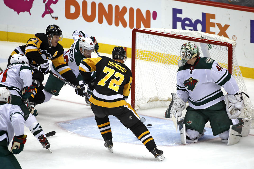 Pittsburgh Penguins' Evgeni Malkin (71) puts the puck behind Minnesota Wild goaltender Devan Dubnyk (40), with Jared Spurgeon (46) defending, for a goal during the first period of an NHL hockey game in Pittsburgh, Tuesday, Jan. 14, 2020. (AP Photo/Gene J. Puskar)