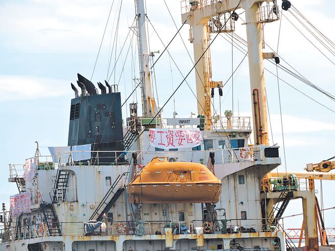 停在高雄港棧貳庫前方水域的貝里斯籍聯利輪，船員掛上白布條紅字寫上「要工資要回家」等字樣。（洪靖宜攝）