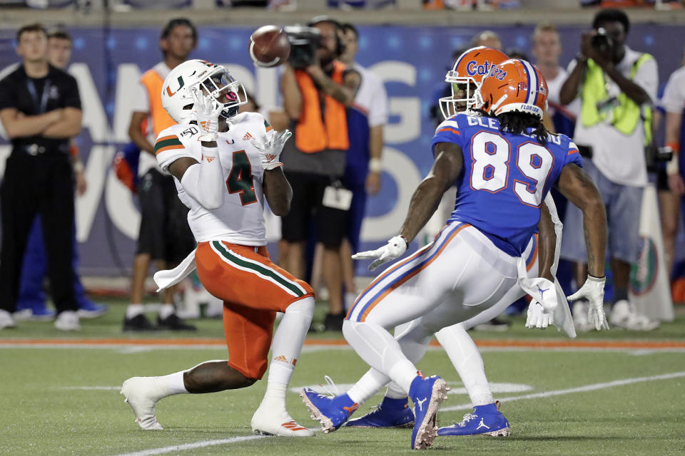 Miami's Jeff Thomas (4) makes a fair catch in front of Florida's Tyrie Cleveland (89) and C.J. McWilliams, back, during the first half of an NCAA college football game Saturday, Aug. 24, 2019, in Orlando, Fla. (AP Photo/John Raoux)