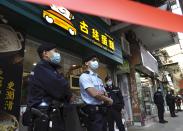 Police officers stand guard outside office of District councillor and lawyer Daniel Wong Kwok-tung, while police searching in Hong Kong, Thursday, Jan. 14, 2021. Wong, a member of the city's Democratic Party, is known for providing legal assistance to hundreds of protesters arrested during the anti-government protests in Hong Kong in 2019. Hong Kong national security police on Thursday arrested a lawyer and 10 others on suspicion of helping 12 Hong Kongers try to flee the city, local media reported in the latest arrests in an ongoing crackdown on dissent. (AP Photo/Vincent Yu)