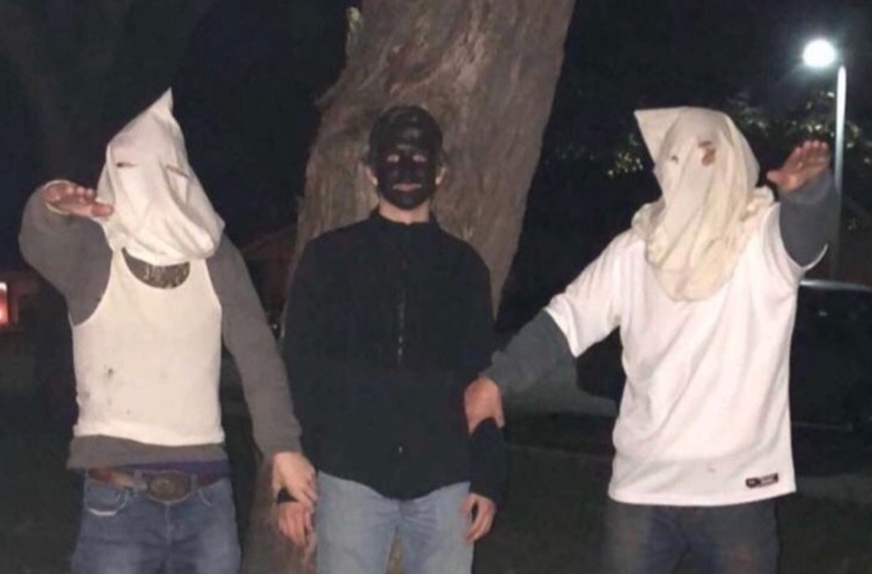 Rochester Public Schools in Minnesota is investigating a photo shared on Snapchat of two students wearing KKK hoods and giving a Nazi salute while one wears blackface. (Photo: Sean Baker via Twitter)