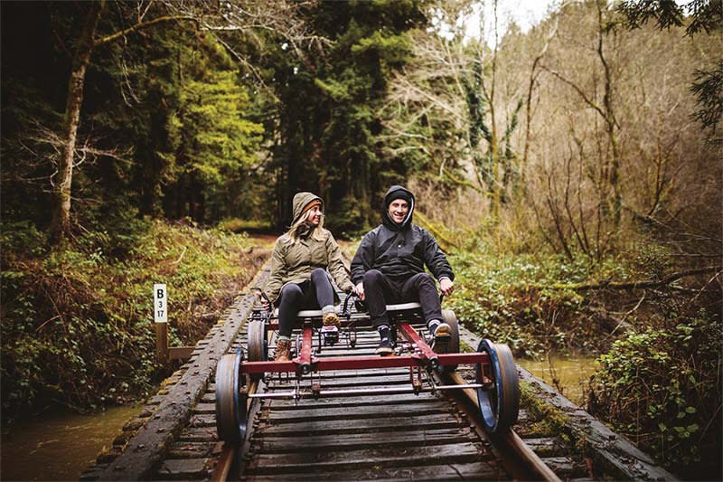 Couple zips through the California redwood forests on an all-electric Skunk Train railbike. 