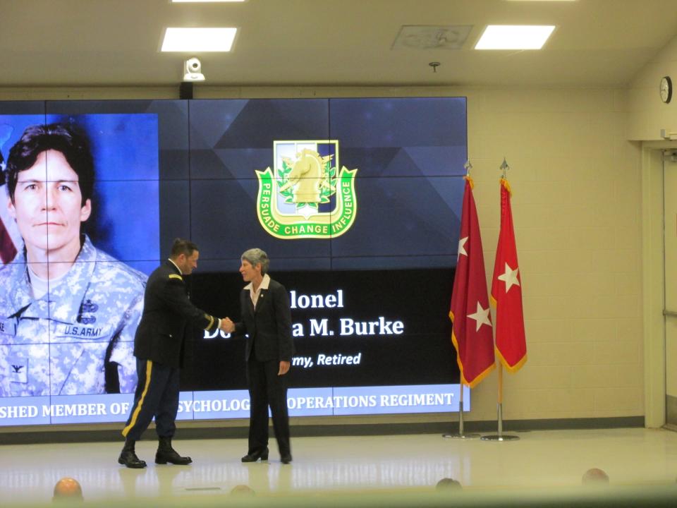 Retired Col. Dorothea Burke is welcomed by Lt. Col. Jeffrey Souther as a distinguished member of the psychological operations regiment during a Nov. 4, 2021, ceremony at Fort Bragg.