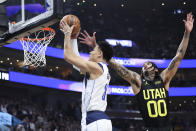 Dallas Mavericks guard Josh Green (8) lays up the ball against Utah Jazz guard Jordan Clarkson (00) in the first quarter of an NBA basketball game Saturday, Jan. 28, 2023, in Salt Lake City. (AP Photo/Rob Gray)