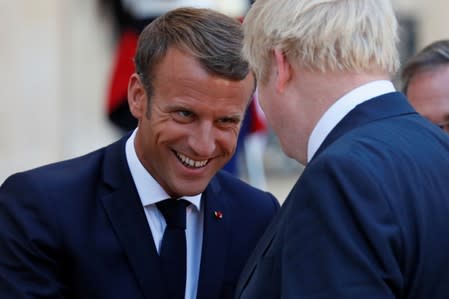 French President Emmanuel Macron accompanies British Prime Minister Boris Johnson after a meeting on Brexit at the Elysee Palace in Paris