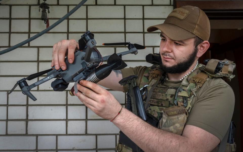 An officer of Ukraine's 59th Motorized Brigade loads a bomb on a drone in the suburbs of Donetsk - Efrem Lukatsky/AP