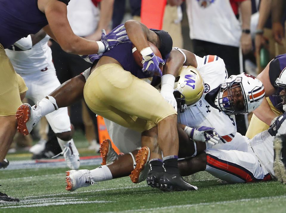 Washington running back Myles Gaskin (9) is stopped by Auburn defensive lineman Derrick Brown (5) after in the first half of an NCAA college football game Saturday, Sept. 1, 2018, in Atlanta. (AP Photo/John Bazemore)