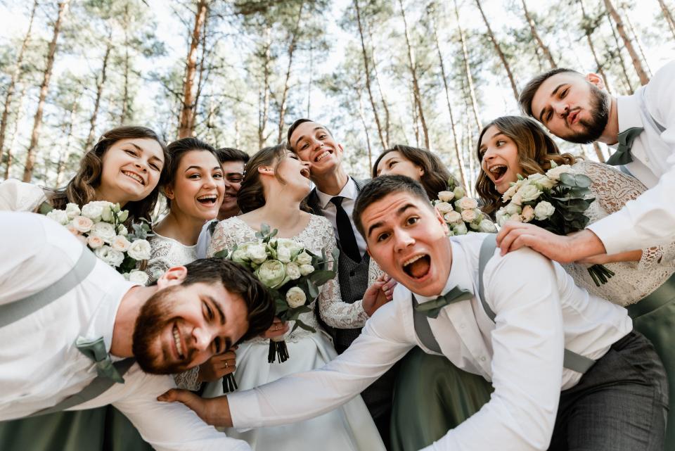 wedding party taking silly photo with bride and groom, candid wedding photo